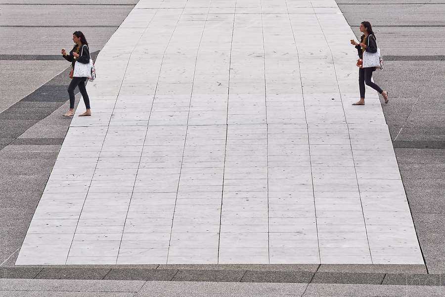 Photomontage d'une femme dédoublée entrant et sortant d'une zone pavée à la Défense