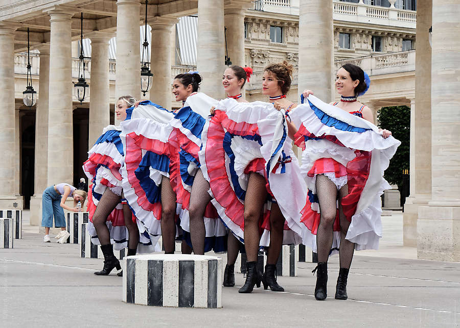 Groupe de danseuses de French Cancan relevant leur robe dans la cour du Palais Royal à Paris