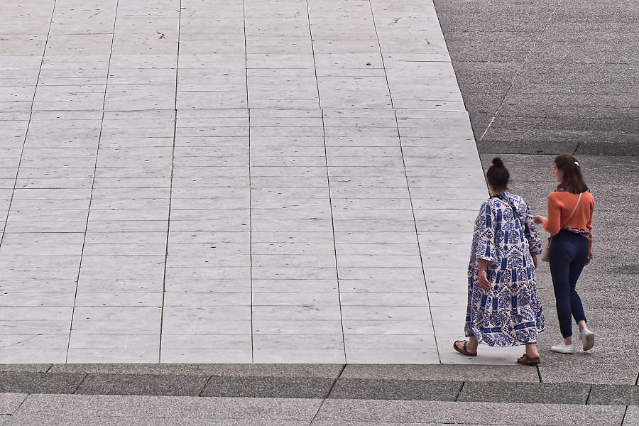 Deux femme qui arrivent à l'angle d'une surface pavée à la Défense