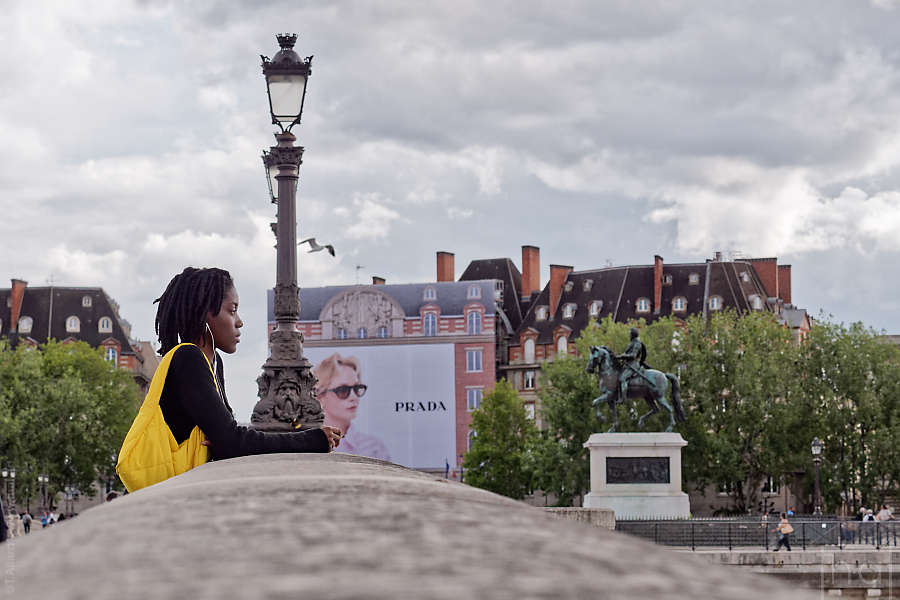 A young woman at the railing of the Pont Neuf in Paris