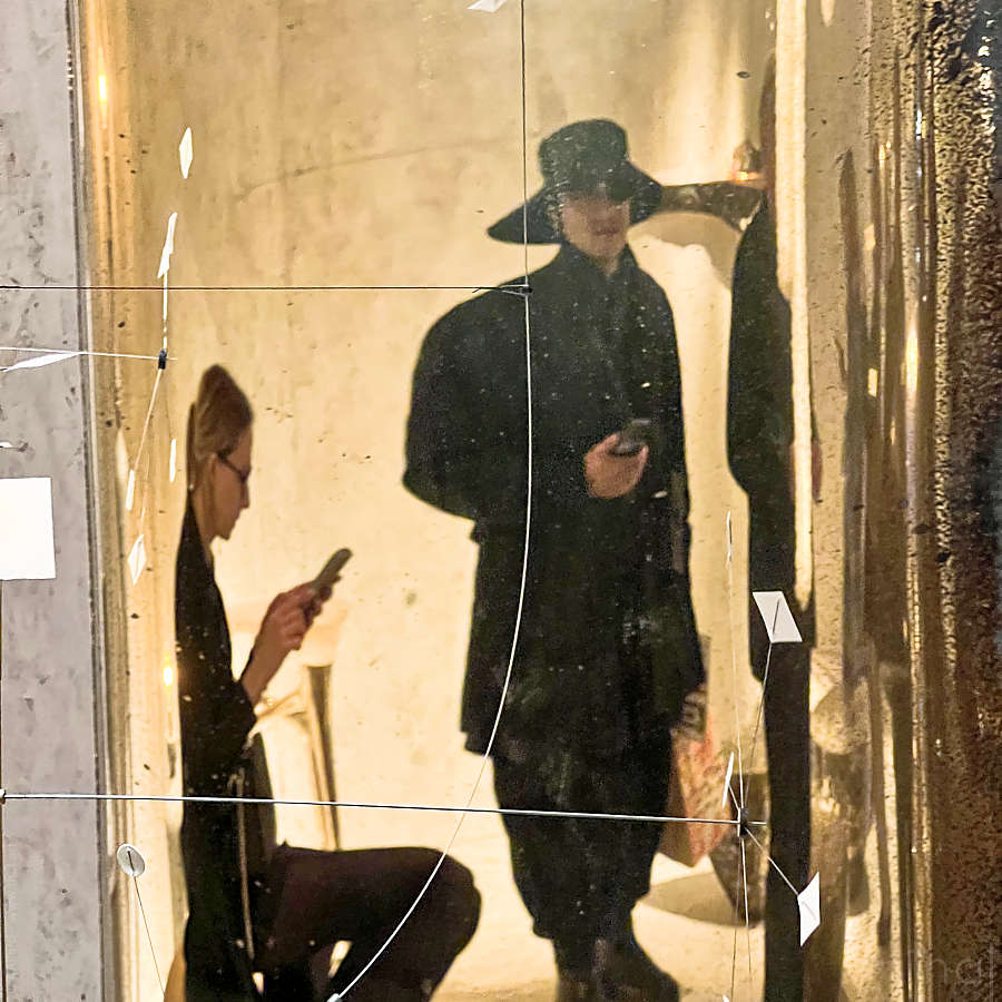 Reflet dans un miroir doré d'un homme avec un chapeau au salon du PAD