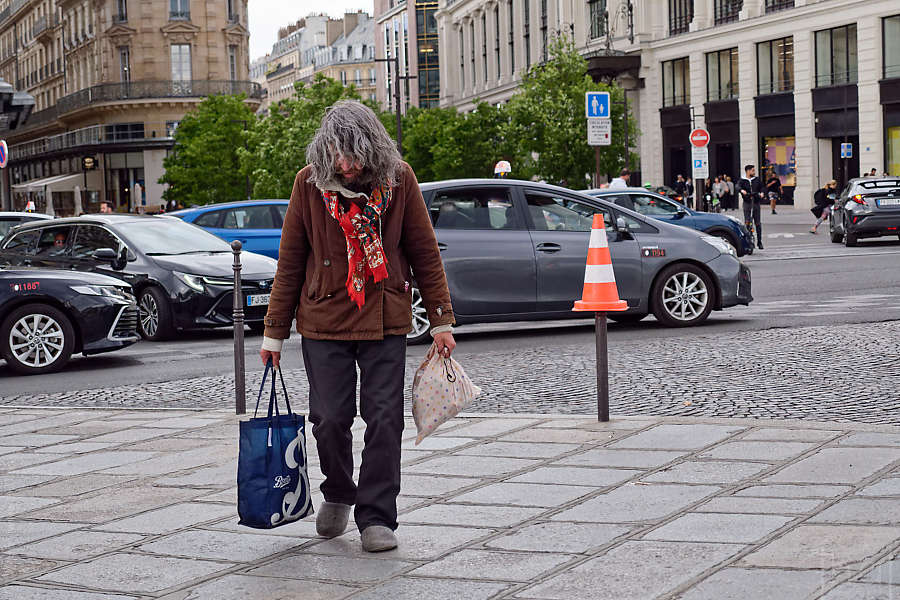 A man walking with his head down and a traffic cone