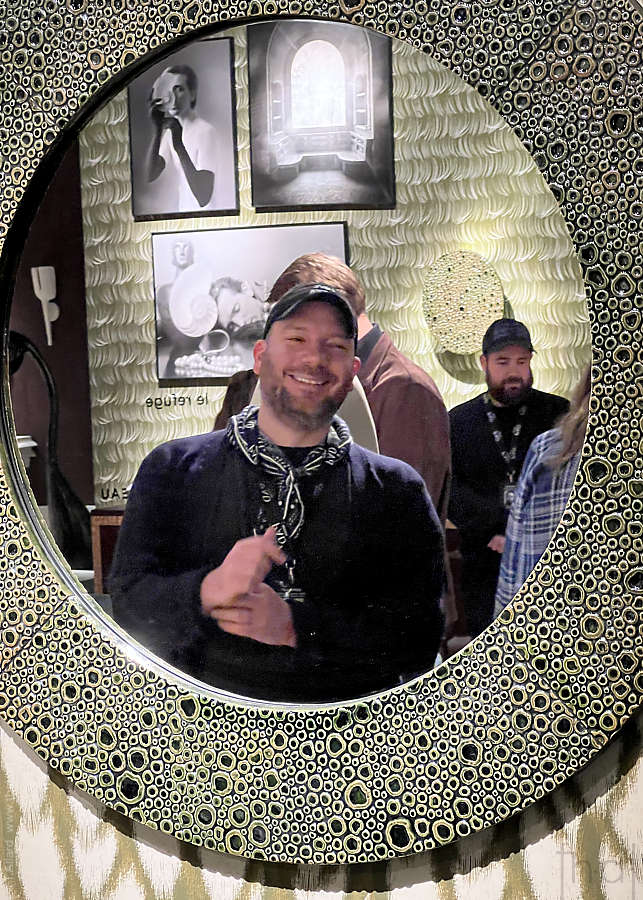 Reflet d'un visage d'homme souriant dans un miroir oval