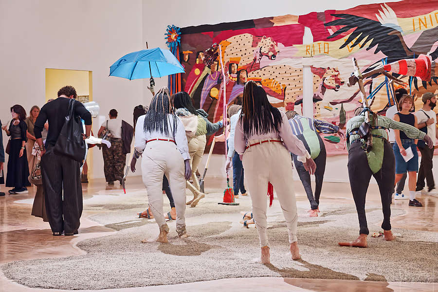 Femme de dos imitant la position des sculptures de femmes