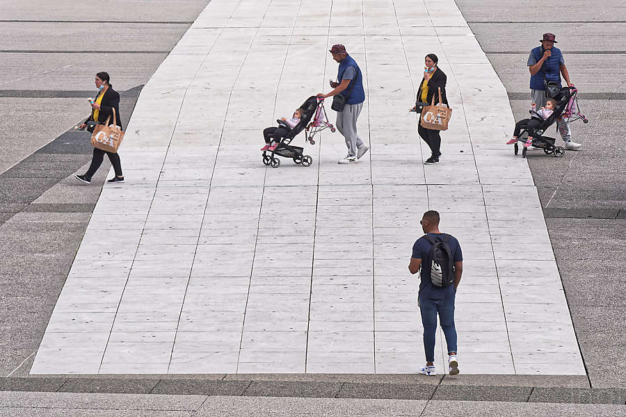 Photomontage d'un couple avec enfant dédoublés traversant l'esplanade de la Défense