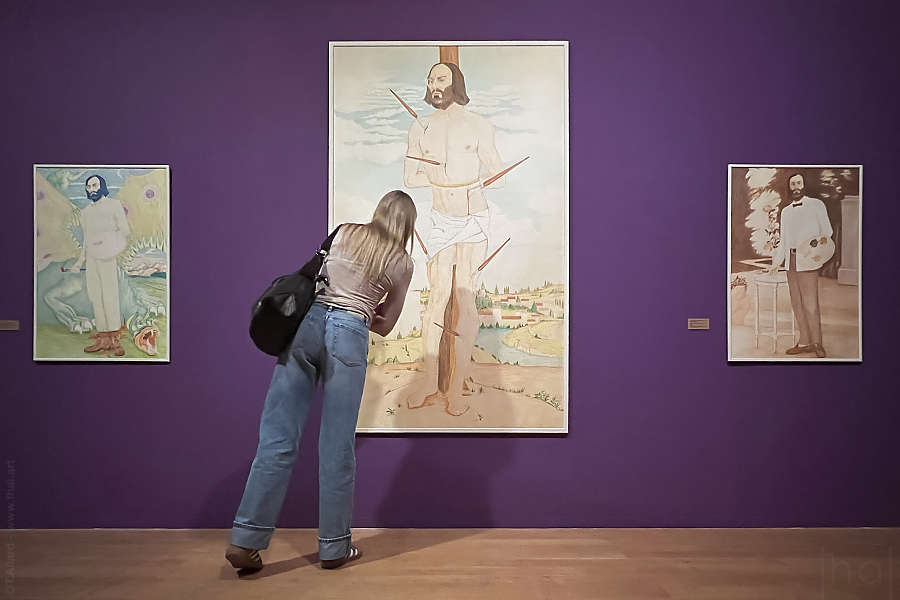 jeune femme observant de près une peinture de Jeune homme tenant un smartphone et tournant le dos à une peinture de Guillaumon en Jésus Christ