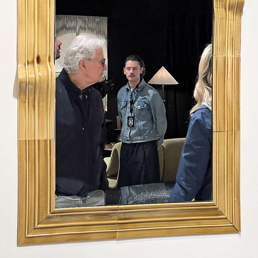 Reflets de visiteurs dans un miroir aux bordures dorées