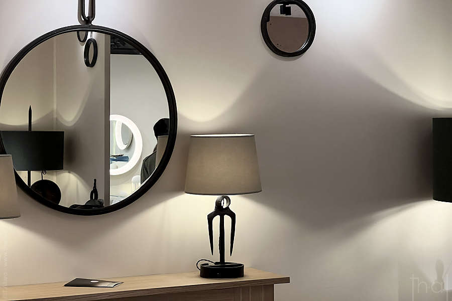 décor meublé avec un miroir et une petite lampe au Salon du PAD