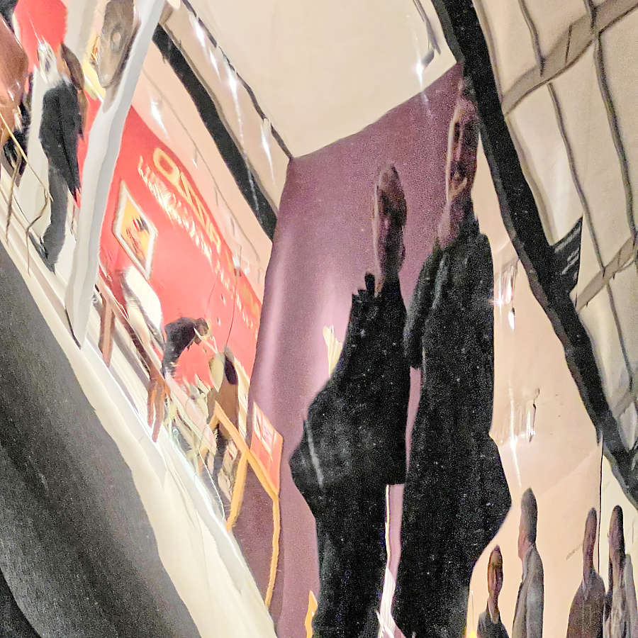 un couple et des visiteurs déformés par un miroir