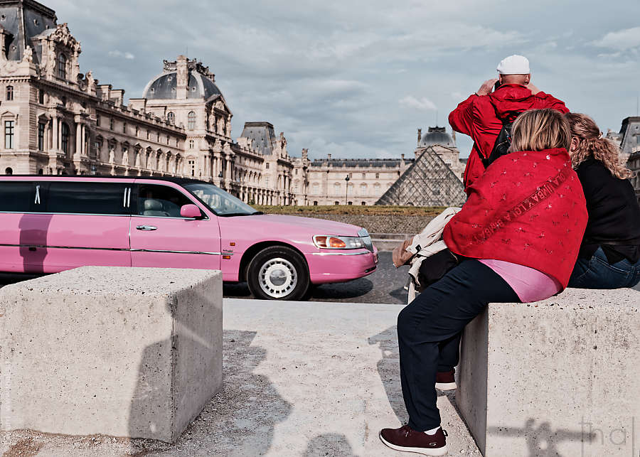 A pink limousine in front of the Louvre Pyramid