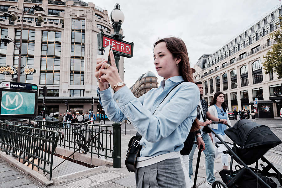 Jeune femme faisant un selfie devant la bouche de métro du Pont Neuf