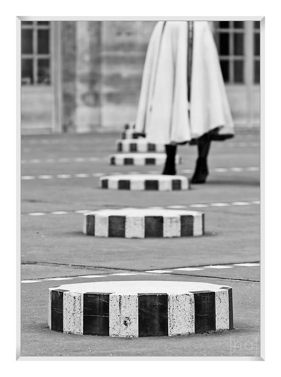 Tirage d'art en noir et blanc d'une danseuse dans un alignement de colonnes de Buren dans la cours du Palais Royal